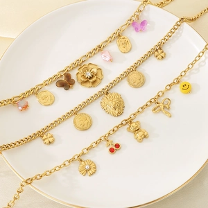 Gold stainless steel chain necklaces with bear lion and flower pendants on a white plate
