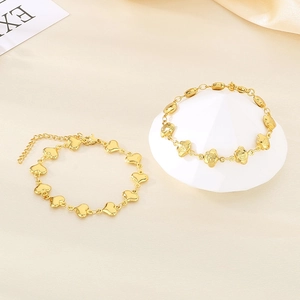 Detail of golden stainless steel bracelets with heart and flower charms and Fu character