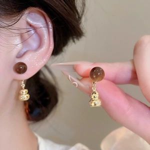 Detail showing vintage tiger eye gourd earrings on model and handheld for close-up view