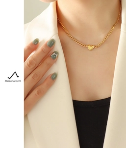 Detailed view of an 18K gold plated stainless steel heart pendant necklace on a model