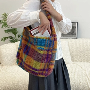 Close-up of spacious colorful plaid plush shoulder bag holding books in casual setting