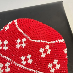 Macro shot of red and white hand-crocheted patterns on a stylish knit fisherman bucket hat