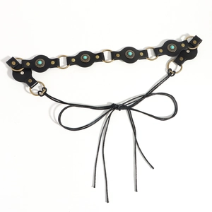 Close-up of bohemian black leather belt with turquoise stones and metal rivets detail