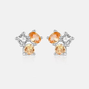 Macro shot of S925 silver stud earrings with white and orange zircon gemstones