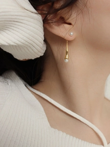 Elegant gold pendant earrings with white pearls shown on model for stylish look