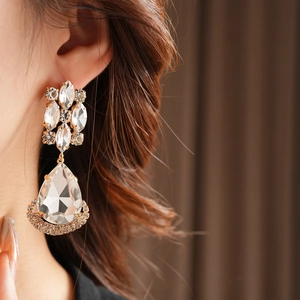 Detail of vintage gold rhombus drop earring with marquise crystals and a large teardrop stone