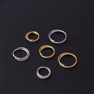 Detail of six 1.2mm stainless steel hoop earrings in gold and silver with zircon accents