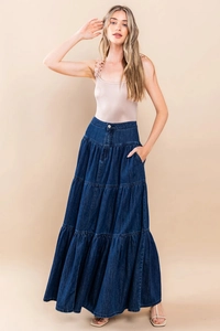 Dettaglio della gonna lunga in denim blu scuro a strati con cuciture e trama lavata
