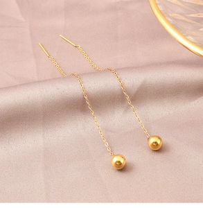 Detail of 18K gold titanium steel long tassel earrings with ball pendants on silk
