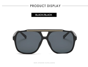 Front view of black oversized pilot sunglasses with a sleek gold metal double bridge detail