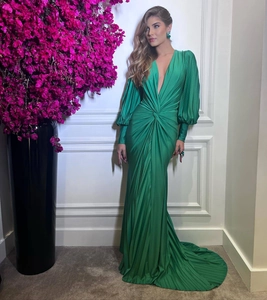 Detail view of emerald green V-neck evening gown with lantern sleeves and waist pleats