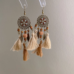 Detailed close-up of Bohemian tassel earrings with wooden beads and bronze petals