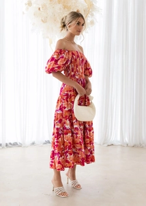 Detail of off-shoulder puff sleeves and vibrant floral print on woven summer dress