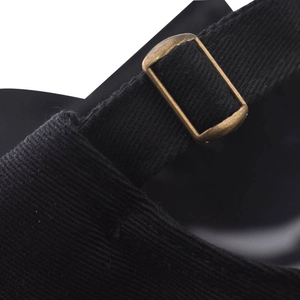 Détail de la boucle métallique et de la sangle en sergé noir de la casquette