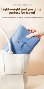Placing a compact blue leather jewelry organizer into a stylish woven tote bag