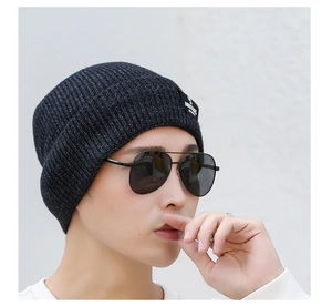 Close-up of the knitted beanie side detail featuring the black Ambitions woven brand label