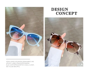 Detail view of cat eye sunglasses featuring tortoiseshell patterns and carved metal hinges