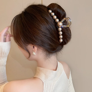 Elegante molletta per capelli in metallo dorato con perle e strass su capelli raccolti