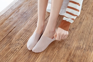 Detailed view of elastic nude invisible boat socks being stretched for a perfect fit