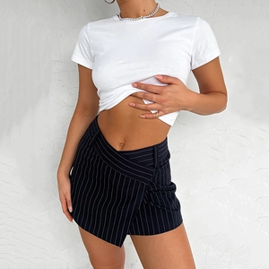 Dettaglio macro della minigonna a righe a vita alta con t-shirt bianca e girovita