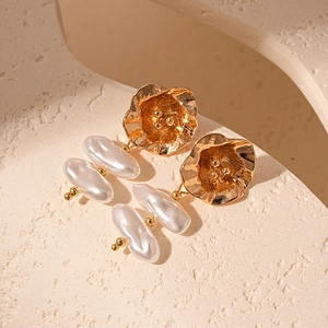 Close-up of vintage baroque faux pearl earrings with hammered gold metal texture