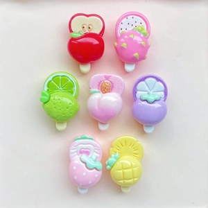 Flat lay of small resin fruit popsicle hair clips including strawberry and apple designs