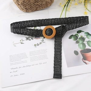 Detail of black woven belt with natural round wooden buckle on a magazine background