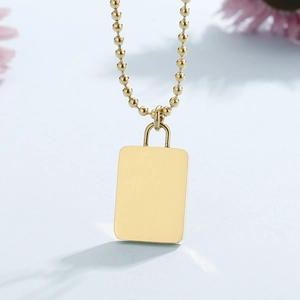 Detailed close-up of golden rectangular pendant necklace on a delicate bead chain
