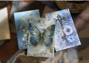 Close-up of vintage scrapbooking paper with blue butterfly, key and floral patterns