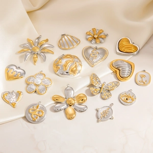 Detailed macro shot of diverse titanium steel heart and butterfly charms on beige silk