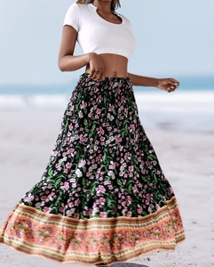 Detail of high waist bohemian floral maxi skirt with elastic waist on beach setting
