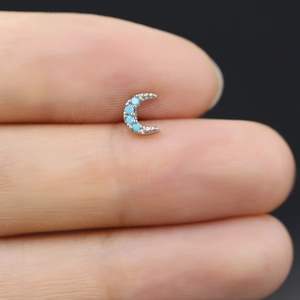 Vista macro di orecchino a mezzaluna in argento con quattro pietre turchesi