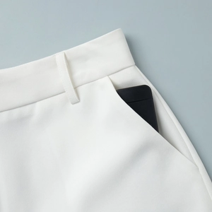 Close-up of white high-waist tailored shorts with deep side pockets and twill fabric