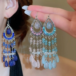 Detail of vintage bohemian teardrop earrings with crystals and dangling glass bead tassels