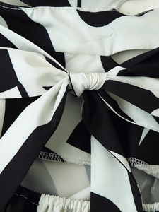 Detail of the waist tie bow and black and white abstract floral pattern on the summer dress