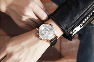Close-up of HEIRID three-eye quartz watch with rose gold case and black leather strap