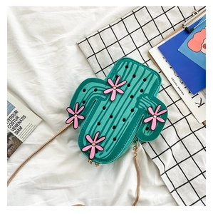 Close-up of cactus shaped crossbody bag with pink flowers and gold chain strap