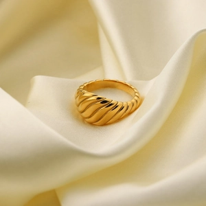 Detalle de anillo croissant chapado en oro 18K con acabado pulido sobre seda