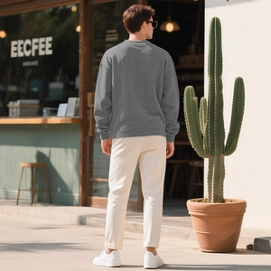 Men's casual loose grey cable-knit long sleeve sweater shown in outdoor cafe setting