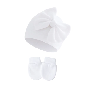 Close-up of soft white knitted newborn hat with bow and matching anti-scratch mittens