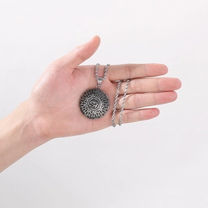 Macro view of Eye of Horus pendant in silver metal with turquoise star on a twist chain