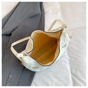 Top view of large capacity white bag interior with yellow lining and smooth metal zipper