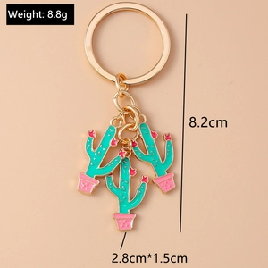 Detail of green and pink cactus charms on a gold keychain with size and weight specs