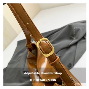 Close-up of brown leather bucket bag with adjustable strap and golden metal buckle
