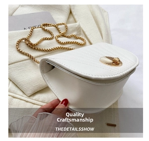 Detail showing white semi-circular saddle bag with golden shell twist lock and chain strap