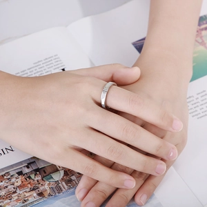 Detailed view of silver polished ring with three inlaid diamonds on a model hand