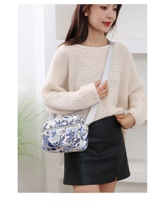 Floral crossbody bag with multi-compartments shown on model in minimal casual outfit