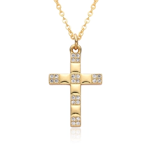 Macro detail of golden cross necklace with micro-pave crystals and polished finish