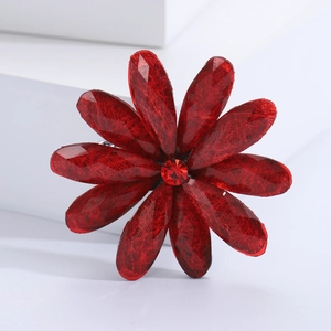 Detailed close-up of a red acrylic flower brooch with resin petals and central gemstone