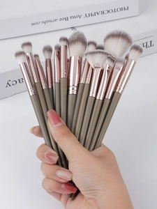 Macro shot of 15 professional makeup brushes with olive green handles and rose gold ferrule